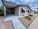 View of the home with an attached carport and sidewalk leading to the front door at 9302 E Broadway Rd # 64, Mesa, AZ 85208