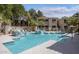 Community pool with several sun loungers surrounded by mature landscaping at 9550 E Thunderbird Rd # 259, Scottsdale, AZ 85260