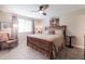 Inviting bedroom featuring a wooden bed frame, ceiling fan, and a cozy seating area near the window at 1021 S Greenfield Rd # 1123, Mesa, AZ 85206