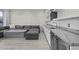 Basement living area with large sectional sofa, stone accent wall, kitchenette with sink and built-in refrigerator at 12593 E Desert Cove Ave, Scottsdale, AZ 85259