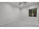 The bedroom has neutral paint, carpeting, ceiling fan, and a view of the fenced backyard at 12593 E Desert Cove Ave, Scottsdale, AZ 85259