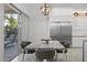 Dining area features sliding glass doors, stainless steel refrigerator, custom light fixture and marble table at 12593 E Desert Cove Ave, Scottsdale, AZ 85259