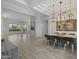 Large dining room featuring a modern chandelier, wood look floors, and views to the living room at 12593 E Desert Cove Ave, Scottsdale, AZ 85259