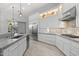 Gourmet kitchen featuring white cabinets, stainless steel appliances, marble countertops, and under cabinet lighting at 12593 E Desert Cove Ave, Scottsdale, AZ 85259