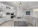 Bright kitchen with white cabinets, stainless steel appliances, and marble countertops with stylish pendant lighting at 12593 E Desert Cove Ave, Scottsdale, AZ 85259