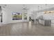Spacious living room featuring lots of natural light, wood look floors, and views to the kitchen at 12593 E Desert Cove Ave, Scottsdale, AZ 85259