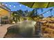 Backyard pool with a waterfall feature, lush landscaping, and ambient string lights at 12593 E Desert Cove Ave, Scottsdale, AZ 85259