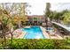 Inviting community pool area surrounded by lounge chairs, mature trees, and landscaping at 1295 N Ash St # 125, Gilbert, AZ 85233