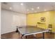 Modern game room with a table tennis setup, bright yellow accent wall, and clean design at 1295 N Ash St # 125, Gilbert, AZ 85233