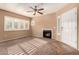 Living room featuring a cozy fireplace, ceiling fan, and lots of light from the large windows at 1295 N Ash St # 125, Gilbert, AZ 85233