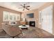 Inviting living room with a fireplace, ceiling fan, and bright windows with plantation shutters at 1295 N Ash St # 125, Gilbert, AZ 85233