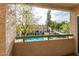 Balcony view of the sparkling community pool surrounded by lush landscaping and seating at 1295 N Ash St # 125, Gilbert, AZ 85233