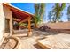 Spacious backyard featuring a covered patio with stone pillars and a custom rock waterfall feature at 1409 W Maria Ln, Tempe, AZ 85284