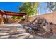 Beautiful outdoor patio with stone waterfall feature and wood pergola at 1409 W Maria Ln, Tempe, AZ 85284