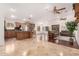 Open-concept living space with tile flooring, ceiling fans, modern sofas, and a kitchen island at 1409 W Maria Ln, Tempe, AZ 85284