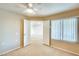 Bedroom features beige walls, tan carpet, ceiling fan and a window with white blinds at 14300 W Bell Rd # 142, Surprise, AZ 85374