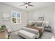 Bright bedroom featuring a ceiling fan, shuttered windows, and stylish decor with neutral color tones at 15039 W Rounders Dr, Surprise, AZ 85374