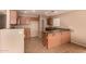 Bright kitchen featuring wood cabinets, a breakfast bar, neutral countertops, and tile flooring at 1585 E Jeanne Ln, San Tan Valley, AZ 85140