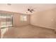 Inviting living room with neutral carpet, sliding glass door access to the backyard, and a ceiling fan at 1585 E Jeanne Ln, San Tan Valley, AZ 85140