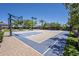 Outdoor basketball court featuring a blue and beige playing surface, surrounded by lush greenery at 18131 W Palo Verde Ct, Litchfield Park, AZ 85340