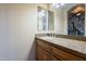 Elegant bathroom vanity with a granite countertop, dual sinks, and decorative lighting at 18131 W Palo Verde Ct, Litchfield Park, AZ 85340