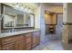Beautiful bathroom vanity with granite counters, a framed mirror, and tile details at 18131 W Palo Verde Ct, Litchfield Park, AZ 85340