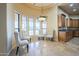 Bright breakfast nook features large windows, chandelier, and seating, adjacent to kitchen with wooden cabinets and granite countertops at 18131 W Palo Verde Ct, Litchfield Park, AZ 85340