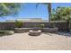 Stone fire pit in a backyard with desert landscaping and a paved patio at 18131 W Palo Verde Ct, Litchfield Park, AZ 85340