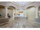 Elegant foyer featuring travertine floors, columns, and views of the living room, creating an inviting atmosphere at 18131 W Palo Verde Ct, Litchfield Park, AZ 85340