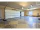 Spacious three car garage featuring overhead lighting and an arched window at 18131 W Palo Verde Ct, Litchfield Park, AZ 85340