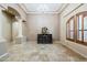 Open-plan living room with columns, travertine floors, and a decorative chandelier at 18131 W Palo Verde Ct, Litchfield Park, AZ 85340