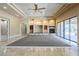 Large living room features travertine flooring, custom shelving, a fireplace, and sliding glass doors to the backyard at 18131 W Palo Verde Ct, Litchfield Park, AZ 85340