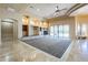 Open living area features a fireplace, custom built-ins, travertine floors, and scenic backyard views through sliding glass doors at 18131 W Palo Verde Ct, Litchfield Park, AZ 85340