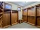 Large walk-in closet showcases custom wood shelving and cabinets, with a bench for convenience at 18131 W Palo Verde Ct, Litchfield Park, AZ 85340