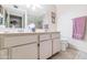 Bright bathroom featuring a double sink vanity and a shower/tub combo with neutral tile at 18655 N Palomar Dr, Sun City West, AZ 85375
