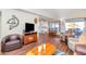 Bright living room with wood floors, comfortable seating, and access to dining area at 18655 N Palomar Dr, Sun City West, AZ 85375