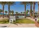 Community swim park rules posted in front of palm trees, pool, and lounging area, all with blue skies in the background at 20477 W Ridge Rd, Buckeye, AZ 85396