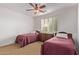 Cozy bedroom with two twin beds, ceiling fan, and carpeted floors at 20934 N Sweet Dreams Dr, Maricopa, AZ 85138