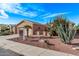 Inviting exterior of a tan home with well-maintained landscaping, mature palms and cacti in front yard at 20934 N Sweet Dreams Dr, Maricopa, AZ 85138