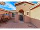 Cozy front patio area with brick pavers, swing, and charming arched doorway at 20934 N Sweet Dreams Dr, Maricopa, AZ 85138