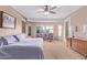 Bright main bedroom with a ceiling fan, and large windows overlooking the backyard at 20934 N Sweet Dreams Dr, Maricopa, AZ 85138