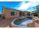 Inviting backyard pool with rock accents, desert landscaping, and covered patio for outdoor entertaining at 20934 N Sweet Dreams Dr, Maricopa, AZ 85138