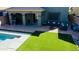 Aerial view of backyard with pool, patio, outdoor seating, and lush artificial turf at 21868 S 215Th St, Queen Creek, AZ 85142