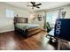 Cozy bedroom with a ceiling fan, hardwood floors and a large computer at 21868 S 215Th St, Queen Creek, AZ 85142