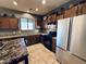 A kitchen featuring stainless steel appliances, granite counters, dark wood cabinets, and tiled floor at 21868 S 215Th St, Queen Creek, AZ 85142
