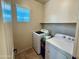 A laundry room complete with a front loading washing machine and top loading dryer at 21868 S 215Th St, Queen Creek, AZ 85142