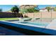 Backyard is a relaxing space that is complete with a private pool, artificial turf, and tall privacy wall at 21868 S 215Th St, Queen Creek, AZ 85142
