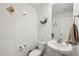 Well-lit half bathroom features a pedestal sink, toilet, neutral paint, decorative elements and a rectangular mirror at 22714 N Chase Dr, Maricopa, AZ 85138