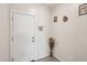 Clean entryway with a white door, neutral walls, and decorative elements like wall art, a key rack and a dried floral arrangement at 22714 N Chase Dr, Maricopa, AZ 85138