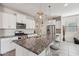 Bright kitchen featuring white cabinetry, granite countertops, a large island, and stainless steel appliances at 22714 N Chase Dr, Maricopa, AZ 85138